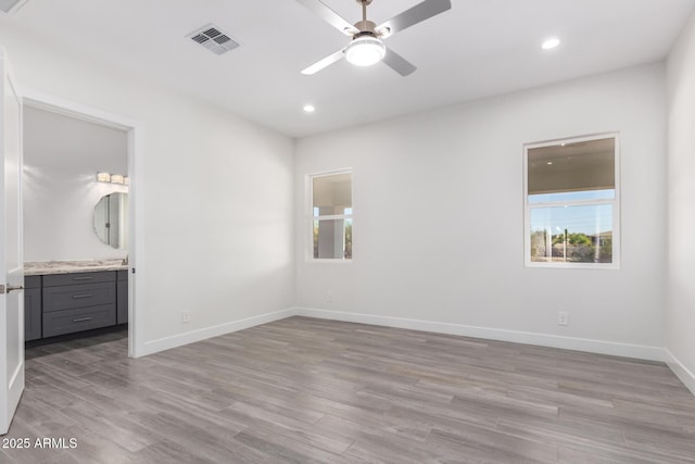 unfurnished bedroom with ensuite bathroom, light hardwood / wood-style floors, and ceiling fan