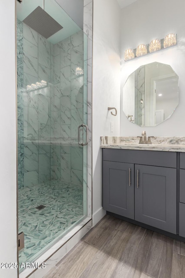 bathroom featuring hardwood / wood-style flooring, vanity, and a shower with shower door