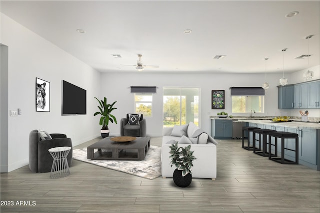 living room featuring ceiling fan and sink