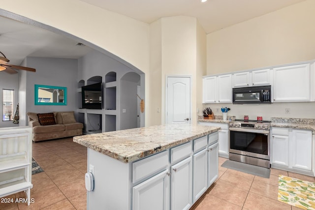 kitchen with white cabinetry, a center island, stainless steel stove, and light tile patterned floors