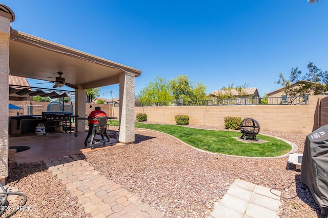 view of yard with an outdoor fire pit, ceiling fan, and a patio area