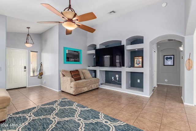 living room with light tile patterned floors, built in shelves, high vaulted ceiling, and ceiling fan