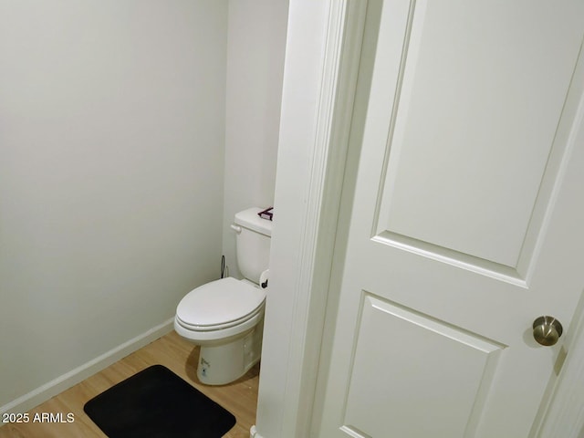 bathroom featuring baseboards, toilet, and wood finished floors