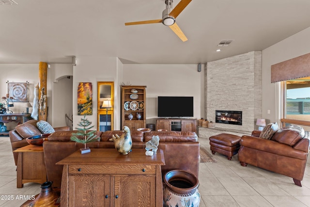 20910 W Cattle Iron Dr, Wickenburg, AZ 85390 - living room with light tile patterned flooring, a fireplace, visible vents, and a ceiling fan