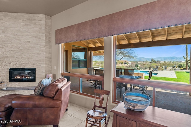 20910 W Cattle Iron Dr, Wickenburg, AZ 85390 - living room featuring a fireplace, a mountain view, and tile patterned flooring