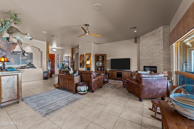 20910 W Cattle Iron Dr, Wickenburg, AZ 85390 - living area with a fireplace, ceiling fan, visible vents, and light tile patterned flooring