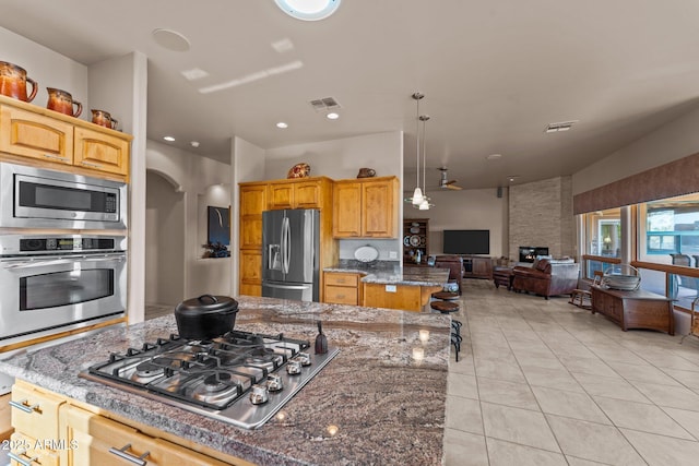 20910 W Cattle Iron Dr, Wickenburg, AZ 85390 - kitchen with dark stone counters, visible vents, stainless steel appliances, and open floor plan