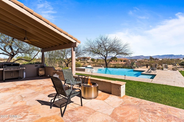 20910 W Cattle Iron Dr, Wickenburg, AZ 85390 - view of patio with a ceiling fan, area for grilling, a mountain view, and an outdoor pool