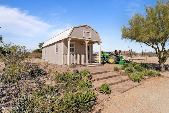 20910 W Cattle Iron Dr, Wickenburg, AZ 85390 - view of front of house with a gambrel roof, an outdoor structure, and fence