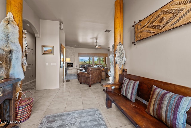 20910 W Cattle Iron Dr, Wickenburg, AZ 85390 - tiled living room featuring a ceiling fan, arched walkways, and visible vents