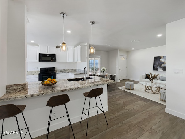 kitchen featuring dark hardwood / wood-style flooring, black appliances, kitchen peninsula, sink, and white cabinets