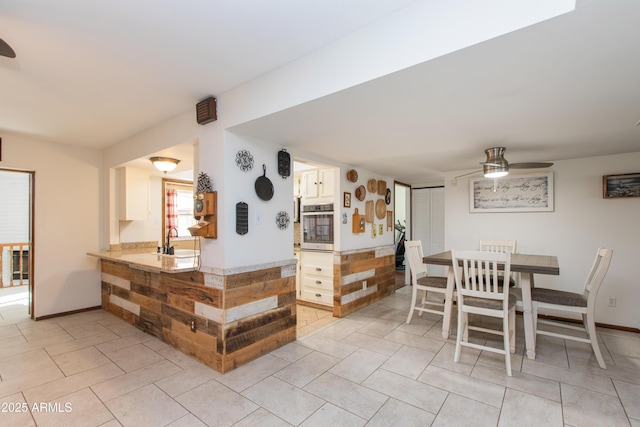 tiled dining room featuring sink and ceiling fan