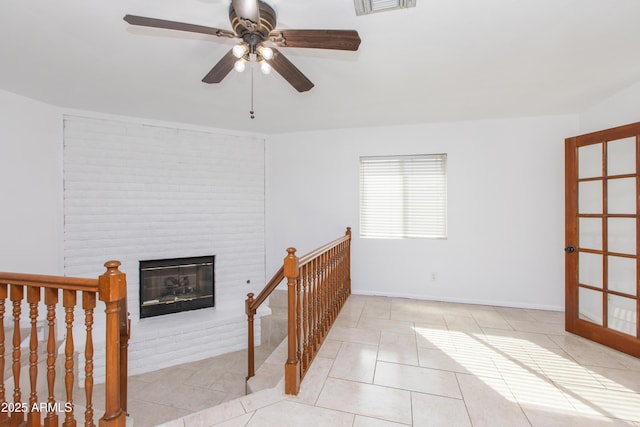 interior space featuring ceiling fan and a fireplace