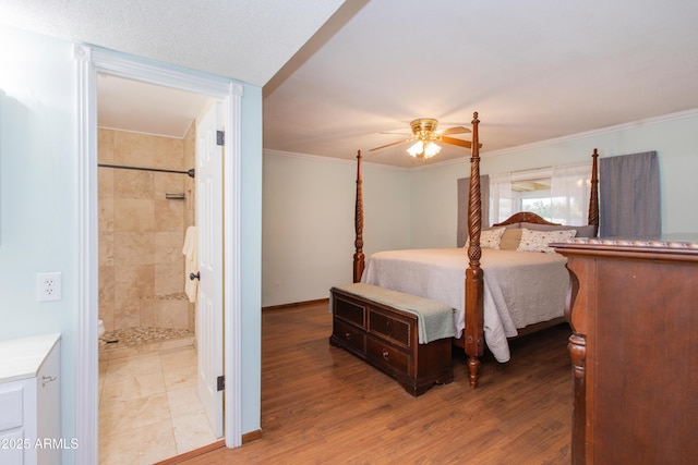 bedroom with ceiling fan, ornamental molding, wood-type flooring, and ensuite bath