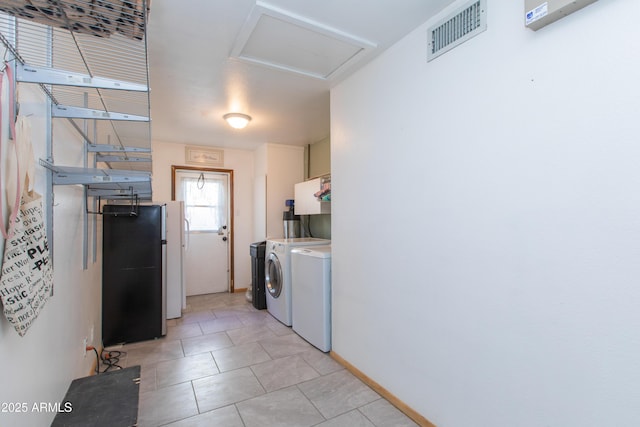 clothes washing area featuring light tile patterned flooring and separate washer and dryer