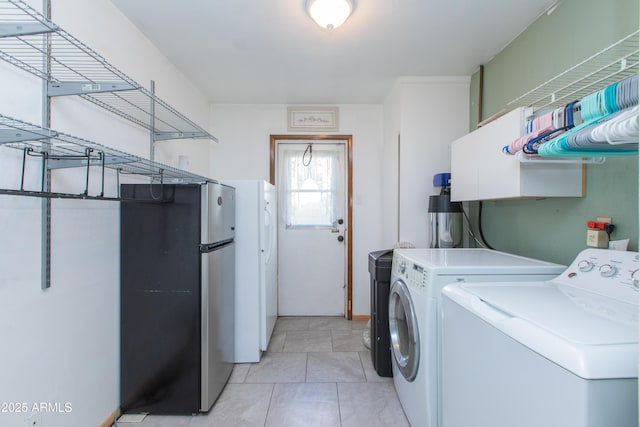 clothes washing area featuring separate washer and dryer and light tile patterned floors