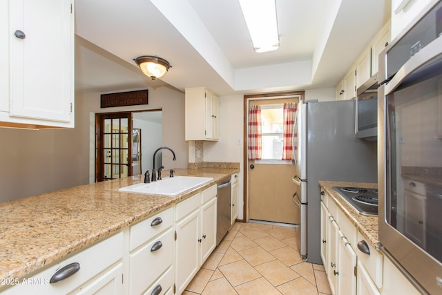 kitchen with dishwasher, white cabinetry, sink, light stone counters, and cooktop