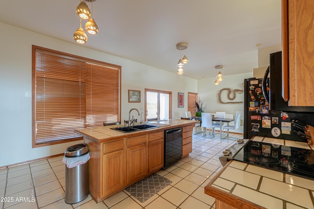 kitchen featuring pendant lighting, sink, tile countertops, and black appliances