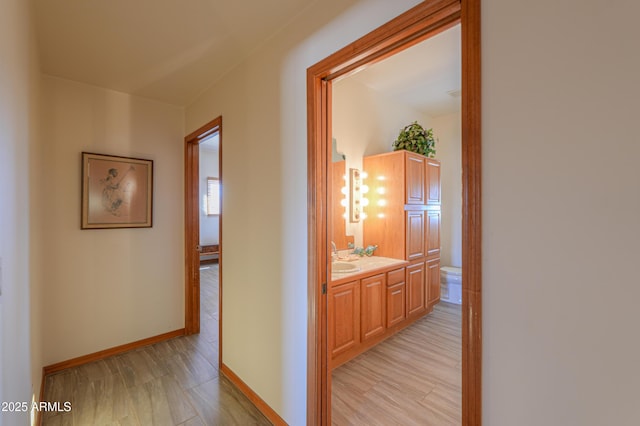 hall with sink and light hardwood / wood-style floors