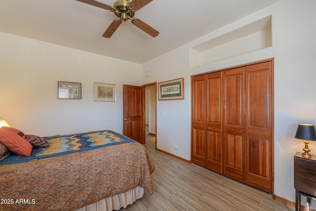 bedroom featuring ceiling fan, a closet, and light wood-type flooring