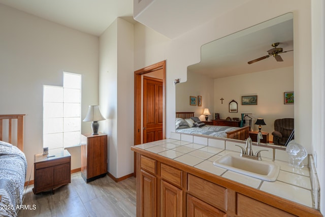 kitchen with sink, tile countertops, and ceiling fan