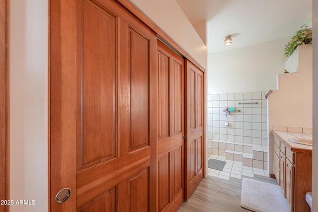 bathroom featuring tile walls, vanity, tile patterned floors, and a shower