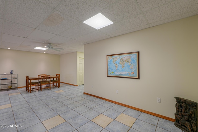 tiled dining area with a paneled ceiling and ceiling fan