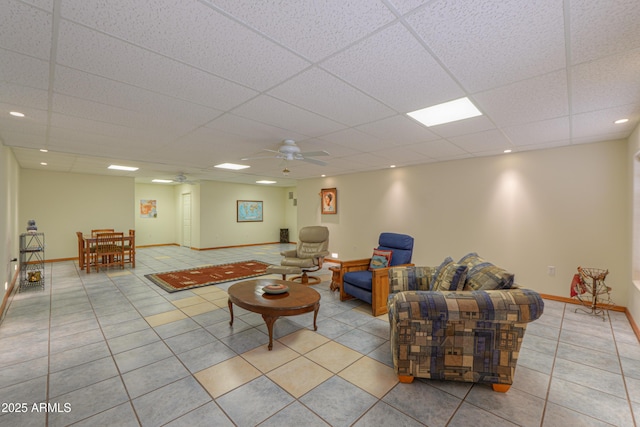 tiled living room with a paneled ceiling and ceiling fan