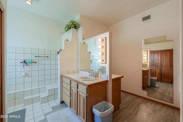 bathroom with vanity and tile walls