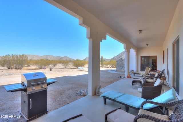 view of patio / terrace with a grill, a fireplace, and a mountain view