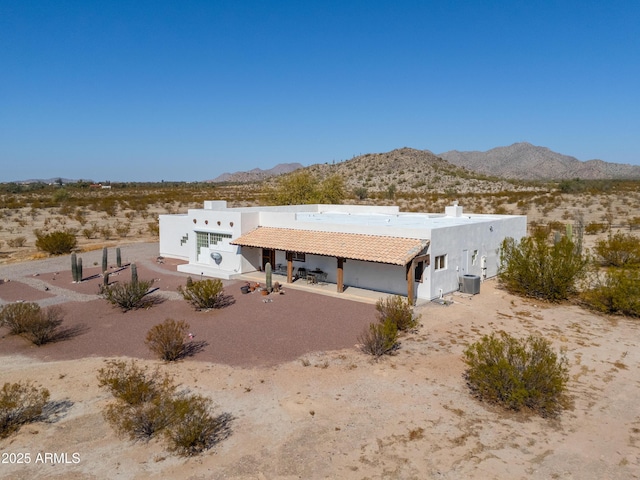 rear view of house with cooling unit and a mountain view