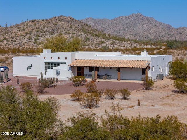 view of front of house featuring a mountain view, central AC, and a patio area