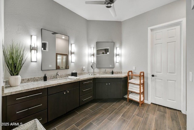 bathroom with a sink, double vanity, a ceiling fan, and wood tiled floor