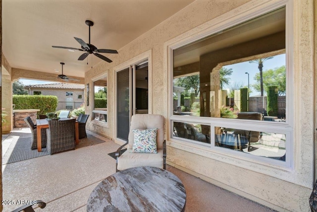 view of patio featuring outdoor dining space, a ceiling fan, and fence