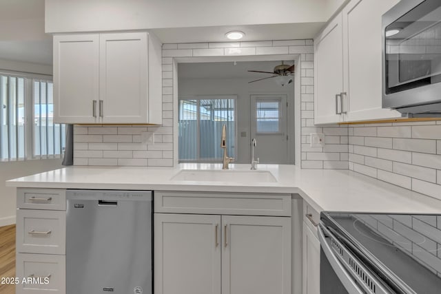 kitchen with light countertops, ceiling fan, a sink, and stainless steel appliances