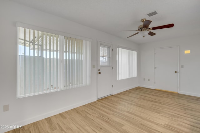 foyer featuring baseboards, ceiling fan, visible vents, and light wood finished floors