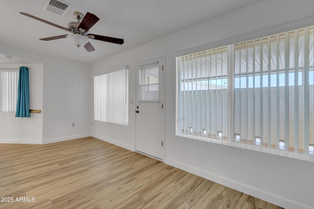 entryway featuring baseboards, a textured ceiling, visible vents, a ceiling fan, and wood finished floors