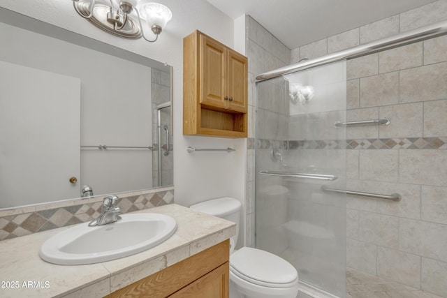 bathroom featuring vanity, toilet, a stall shower, and a notable chandelier