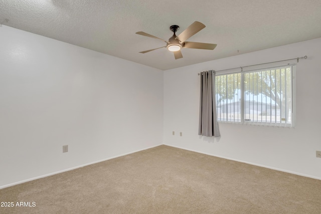 carpeted spare room with a textured ceiling and ceiling fan