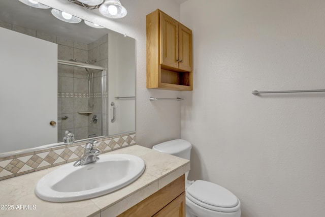 full bath with toilet, vanity, and tiled shower