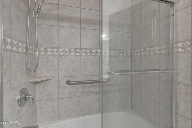 bathroom featuring combined bath / shower with glass door