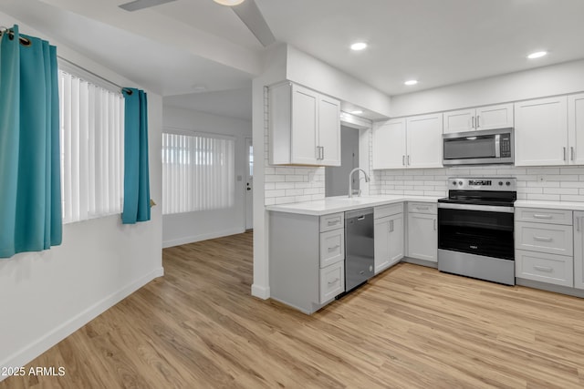 kitchen featuring light countertops, stainless steel appliances, and light wood finished floors
