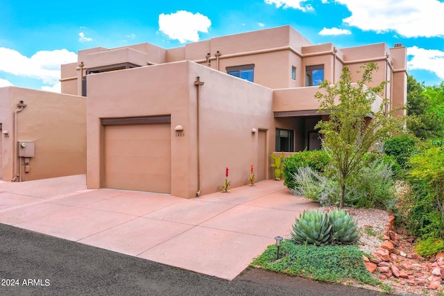 pueblo revival-style home featuring a garage