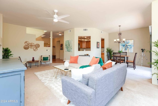 carpeted living room featuring ceiling fan with notable chandelier