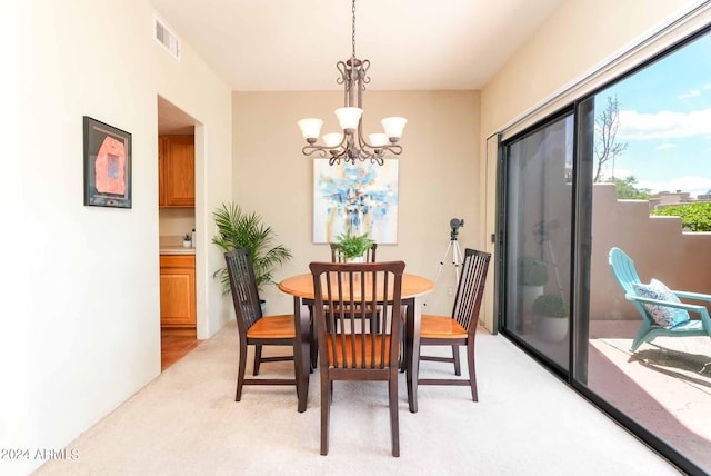 dining room with a notable chandelier and light carpet