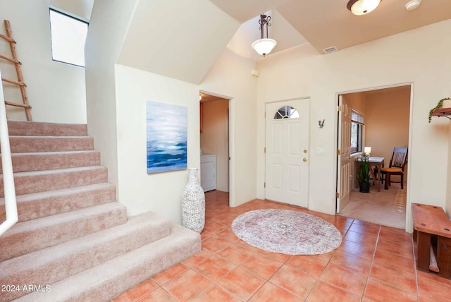 foyer entrance with washer / dryer and tile patterned floors