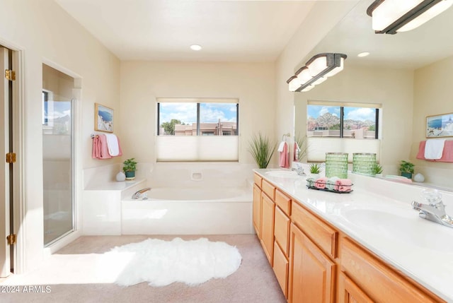 bathroom featuring a healthy amount of sunlight, vanity, and shower with separate bathtub