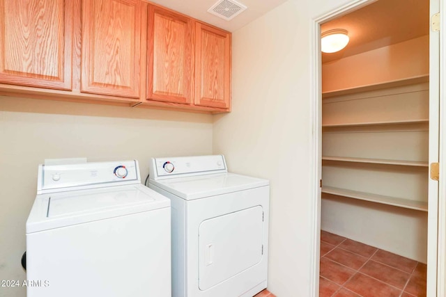 clothes washing area with cabinets, separate washer and dryer, and light tile patterned floors