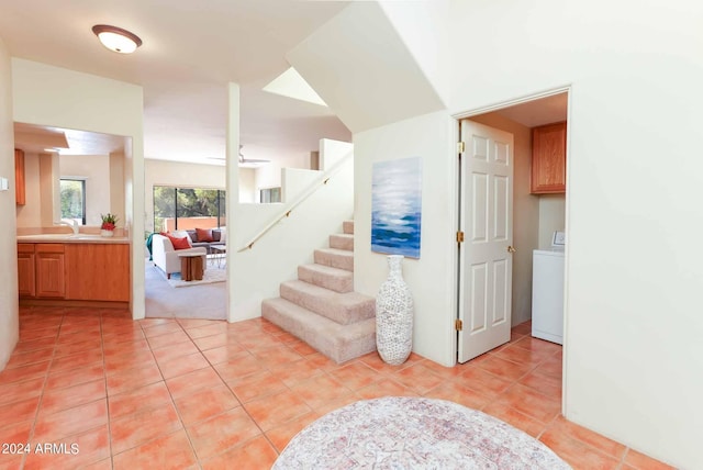 staircase featuring sink, washer / dryer, and tile patterned flooring