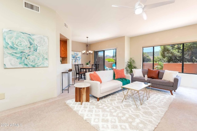 living room with ceiling fan with notable chandelier, a healthy amount of sunlight, and light colored carpet